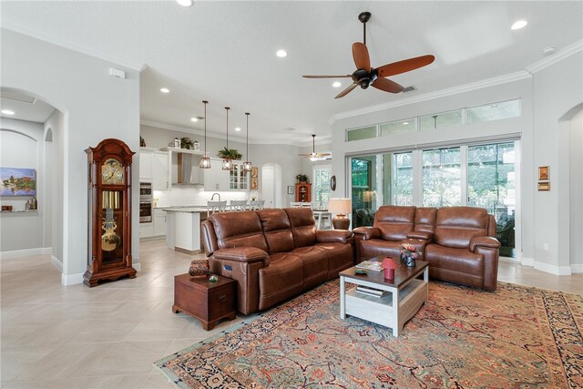 living room with ornamental molding, light tile patterned floors, and ceiling fan