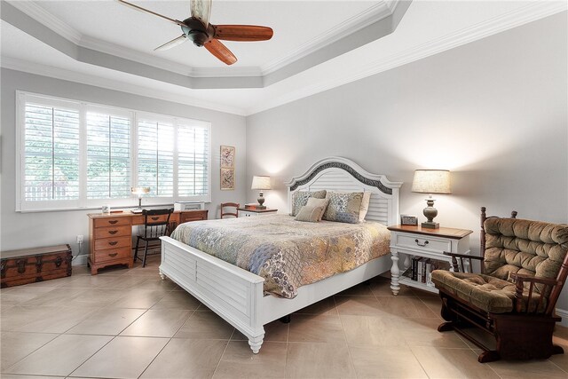 bedroom with ceiling fan, tile patterned flooring, a tray ceiling, and ornamental molding