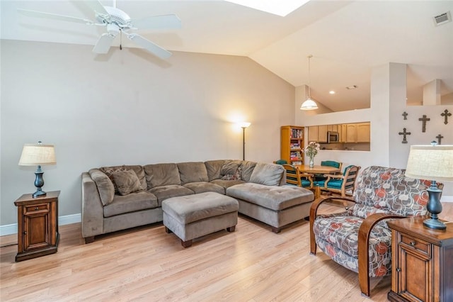 living room with ceiling fan, light wood-type flooring, and vaulted ceiling