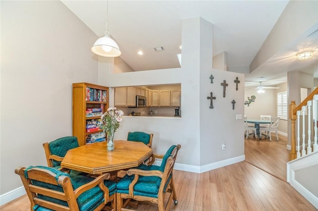 dining area featuring light wood-type flooring, high vaulted ceiling, and ceiling fan