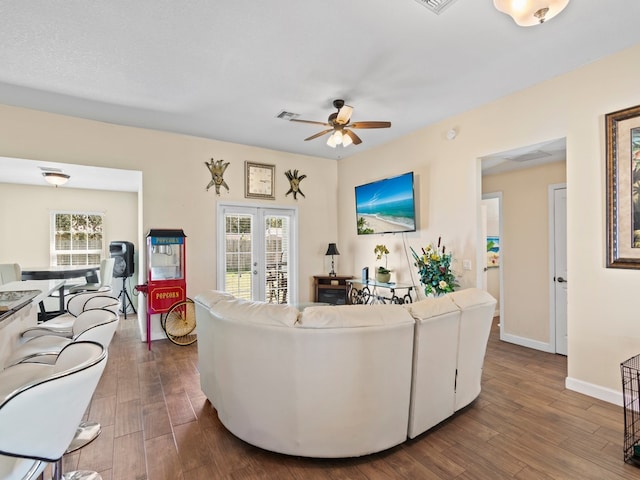 living room with hardwood / wood-style flooring, ceiling fan, and french doors