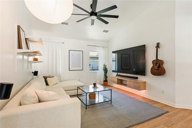 living room with visible vents, baseboards, vaulted ceiling, wood finished floors, and a ceiling fan