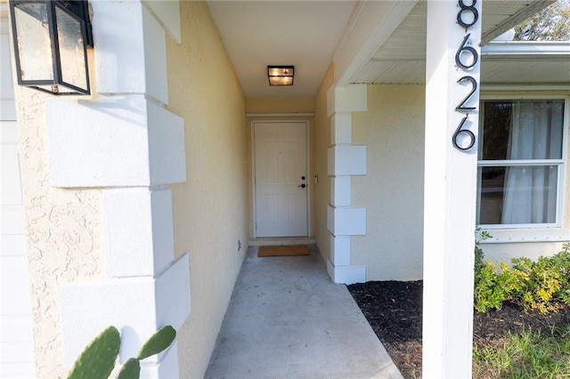 entrance to property featuring stucco siding