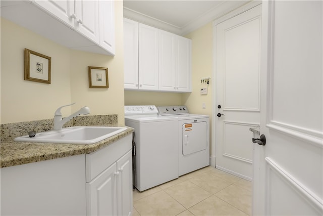 clothes washing area featuring cabinets, light tile patterned floors, sink, crown molding, and washer and dryer