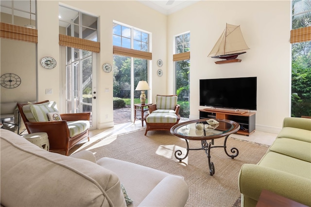 living room featuring a wealth of natural light, light tile patterned floors, and a towering ceiling