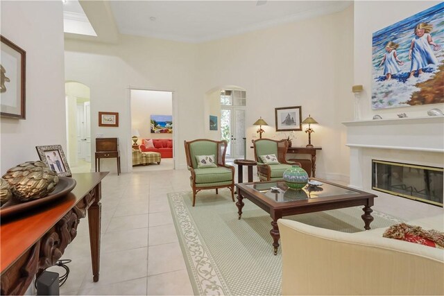1632 Weybridge Cir, Vero Beach, FL 32963 - living area featuring arched walkways, a glass covered fireplace, light tile patterned floors, and a high ceiling