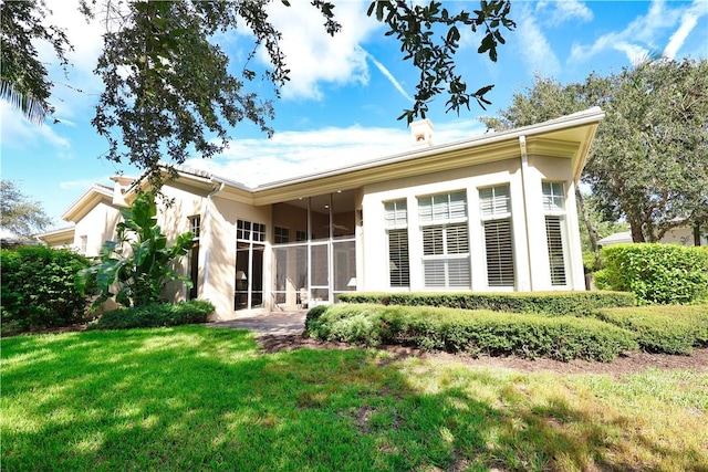 1632 Weybridge Cir, Vero Beach, FL 32963 - rear view of house with a lawn, a sunroom, and stucco siding