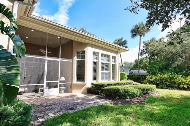 1632 Weybridge Cir, Vero Beach, FL 32963 - rear view of house with ceiling fan, a sunroom, a patio, and stucco siding