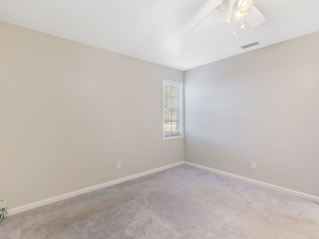 spare room featuring ceiling fan and light colored carpet