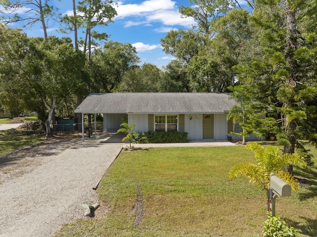 ranch-style home featuring a front yard and a carport