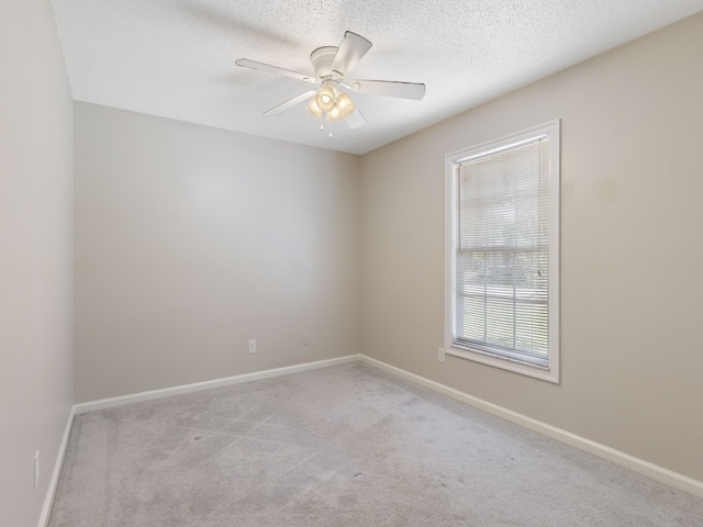 carpeted spare room with ceiling fan and a textured ceiling