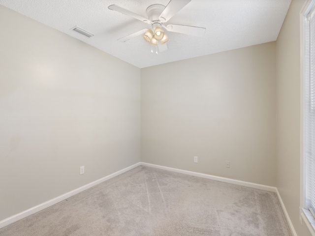 carpeted empty room featuring ceiling fan and a textured ceiling