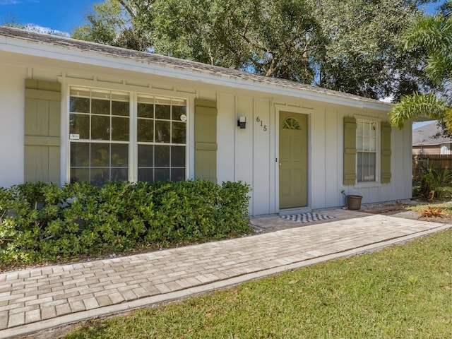 view of exterior entry with a lawn