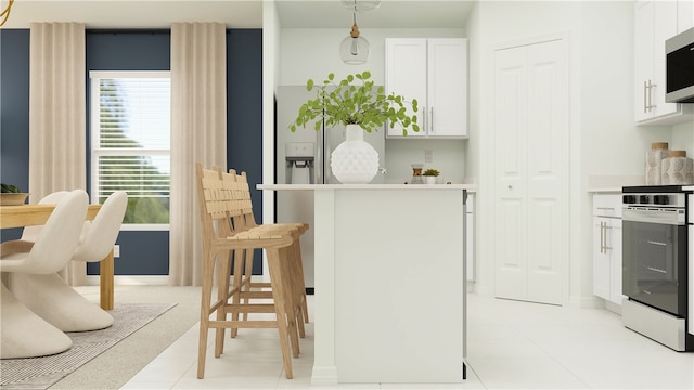 kitchen featuring light carpet, a kitchen bar, stainless steel appliances, hanging light fixtures, and white cabinets