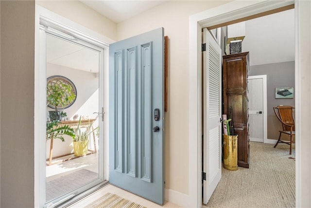 foyer entrance with light carpet and baseboards