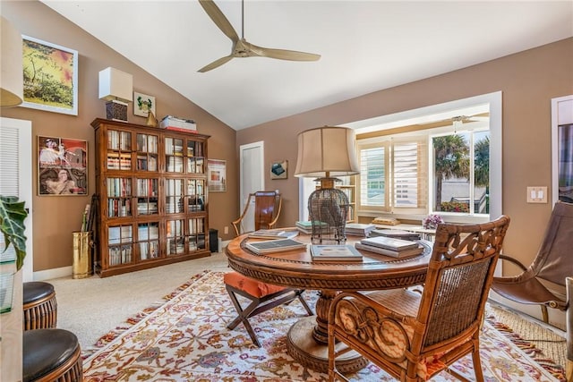 carpeted dining space featuring baseboards, lofted ceiling, and ceiling fan