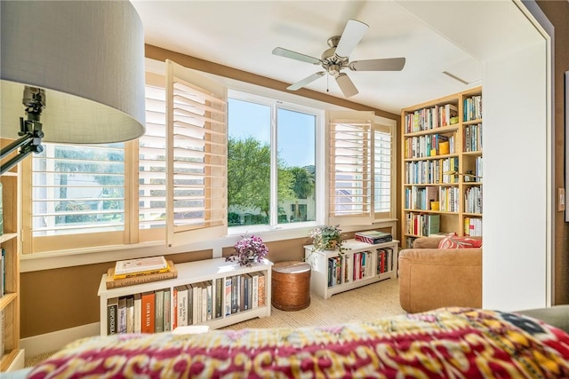 living area featuring carpet flooring and a ceiling fan