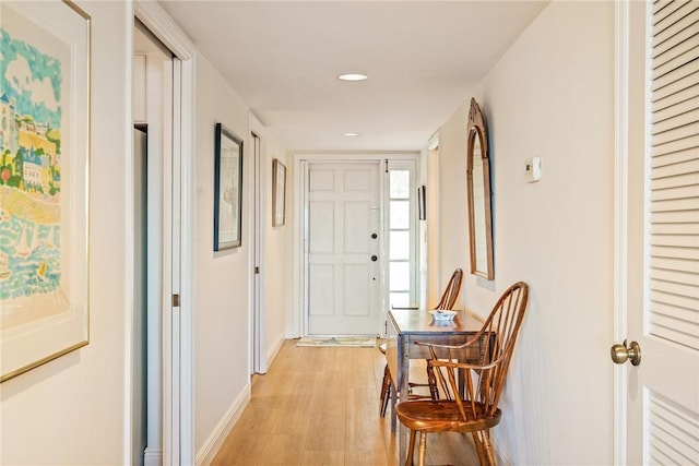 hallway featuring recessed lighting, baseboards, and light wood finished floors