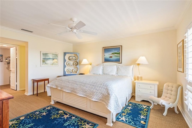 bedroom with visible vents, crown molding, baseboards, light carpet, and a ceiling fan