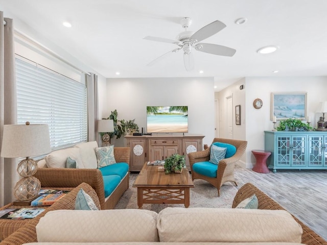 living room with ceiling fan and light hardwood / wood-style flooring