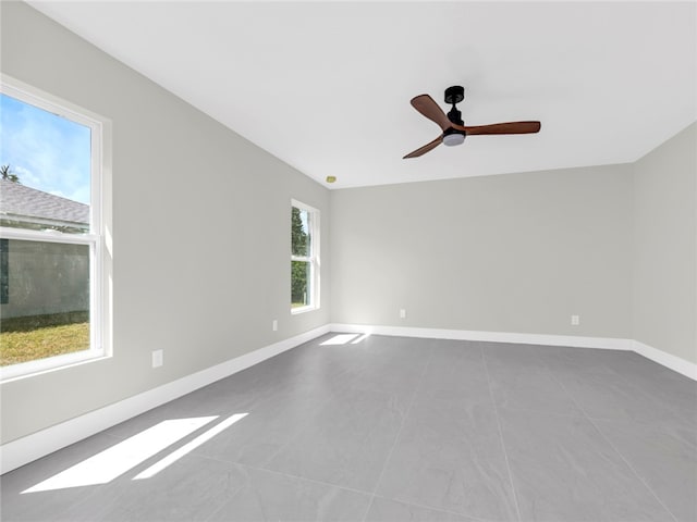 tiled spare room with a wealth of natural light and ceiling fan