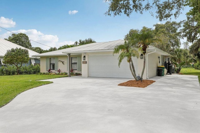 9830 Oak Trl, Sebastian, FL 32976 - ranch-style house featuring a garage, driveway, a front yard, and a metal roof