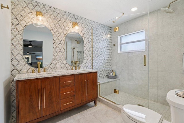 9830 Oak Trl, Sebastian, FL 32976 - full bath featuring a stall shower, tile patterned floors, double vanity, tile walls, and ceiling fan