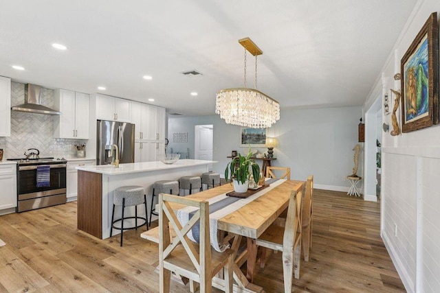 9830 Oak Trl, Sebastian, FL 32976 - dining space featuring light wood finished floors, a chandelier, and recessed lighting