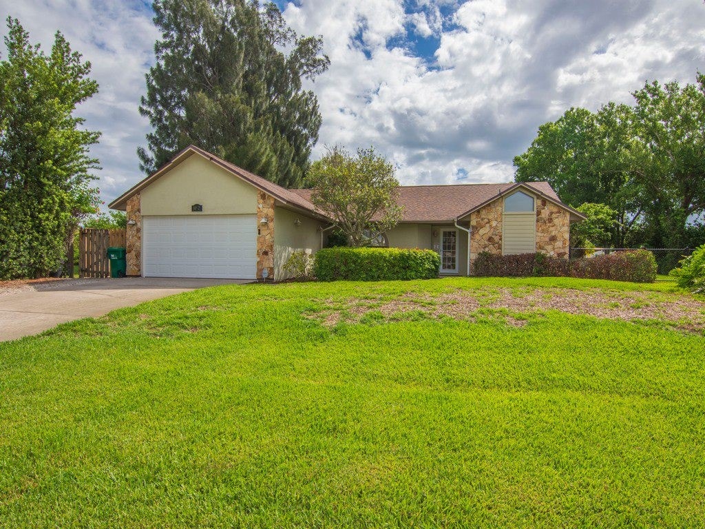 single story home with a front yard and a garage