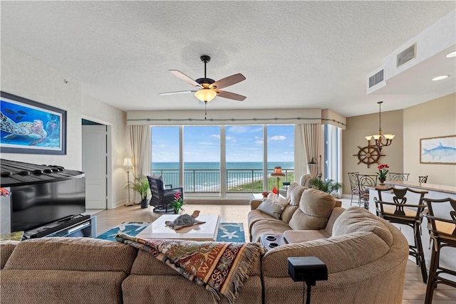 3000 N Aia Hwy N Phgc, Phgc, Hutchinson Island, FL 34949 - living room with light wood-style floors, a water view, ceiling fan with notable chandelier, and visible vents