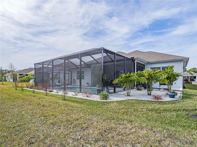 back of house with a patio area, a lawn, and glass enclosure