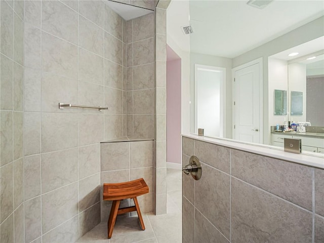 bathroom featuring tile patterned flooring, a shower, and tile walls