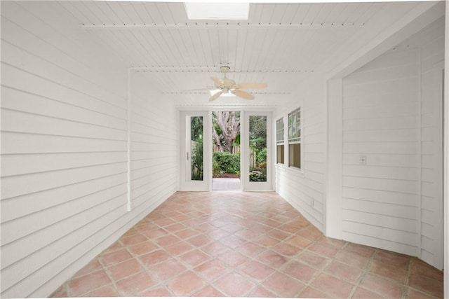 unfurnished sunroom with a skylight, wooden ceiling, and ceiling fan