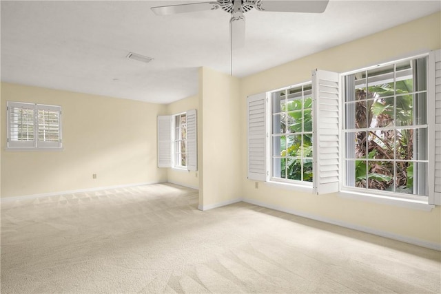 carpeted spare room with a healthy amount of sunlight and ceiling fan