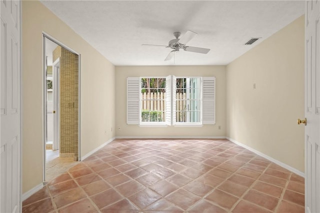 spare room with ceiling fan and tile patterned flooring