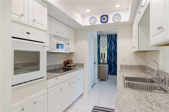 5151 A1A Hwy Unit 506, Indian River Shores, FL 32963 - kitchen featuring white appliances, light tile patterned flooring, white cabinets, light countertops, and a tray ceiling