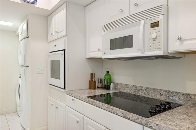 5151 A1A Hwy Unit 506, Indian River Shores, FL 32963 - kitchen featuring white appliances, white cabinets, light countertops, and light tile patterned flooring