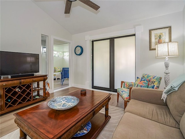 living room featuring ceiling fan, light hardwood / wood-style floors, and lofted ceiling