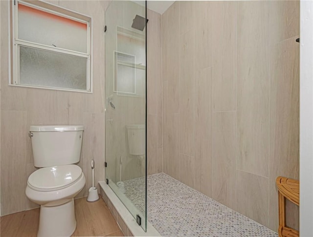 bathroom featuring a tile shower and toilet