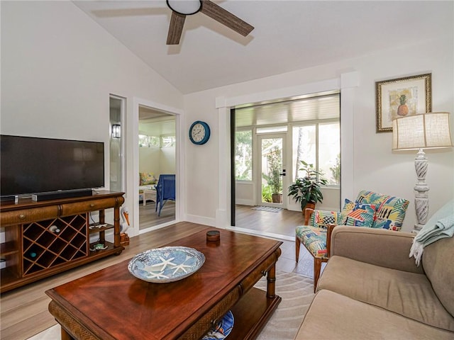 living room featuring ceiling fan, light hardwood / wood-style floors, and vaulted ceiling