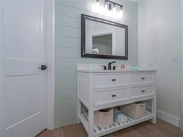 bathroom with vanity, hardwood / wood-style flooring, and wood walls