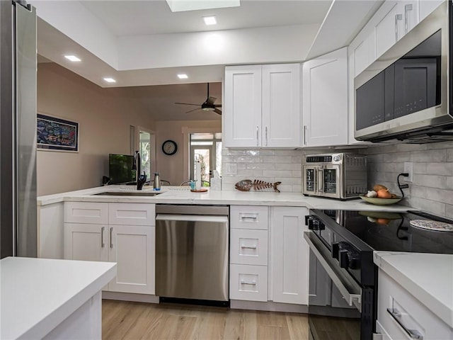 kitchen with decorative backsplash, white cabinetry, sink, and stainless steel appliances