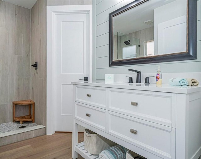 bathroom featuring vanity, wood-type flooring, and walk in shower