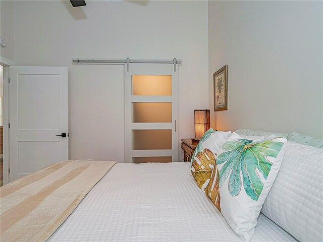 bedroom with a barn door and ceiling fan