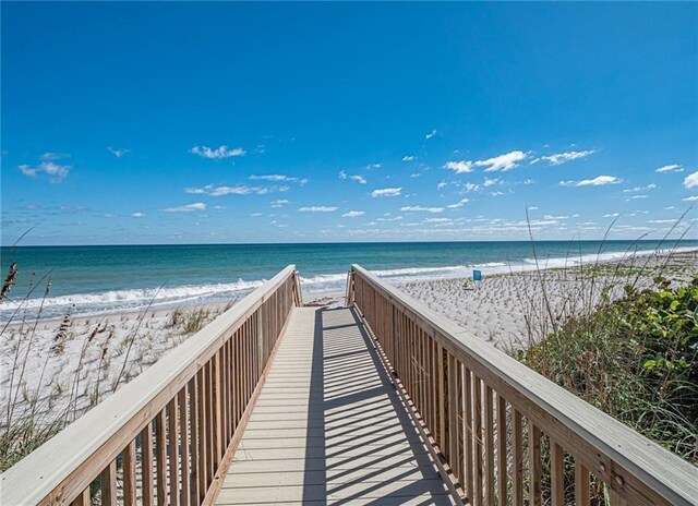 view of home's community with a beach view and a water view