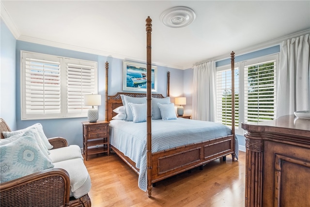 bedroom with ornamental molding and light hardwood / wood-style flooring