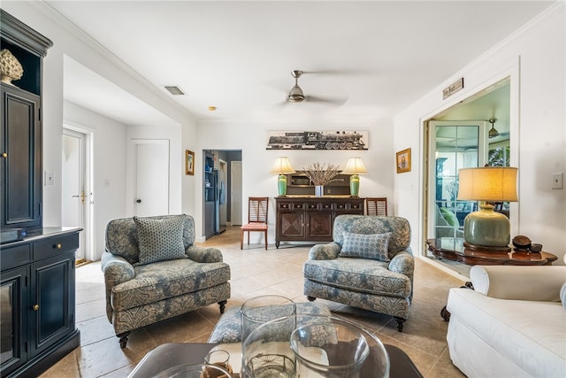 tiled living room with ceiling fan and ornamental molding