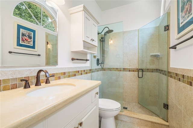 bathroom featuring tile walls, an enclosed shower, vanity, and toilet