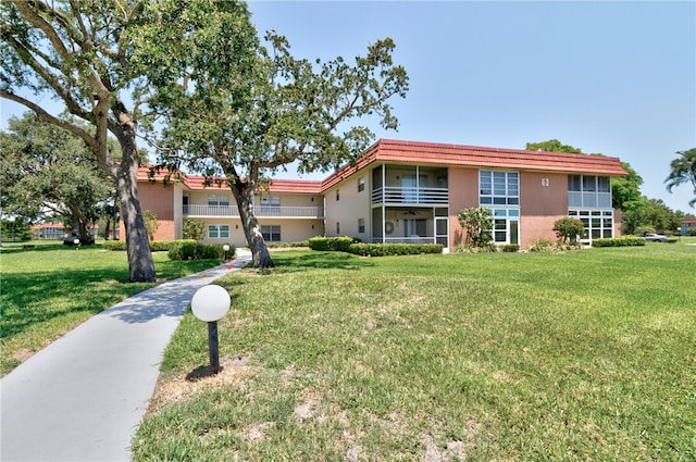 view of front of house with a front yard and a balcony