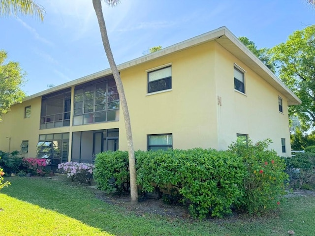 view of home's exterior with a lawn and stucco siding